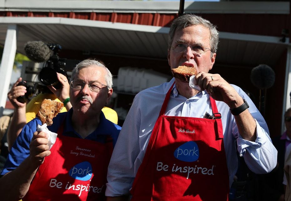 Former Florida Gov. Jeb Bush and then-Iowa Gov. Terry Branstad eat pork chop on a stick at the 2015 Iowa State Fair. Branstad is now ambassador to China.
