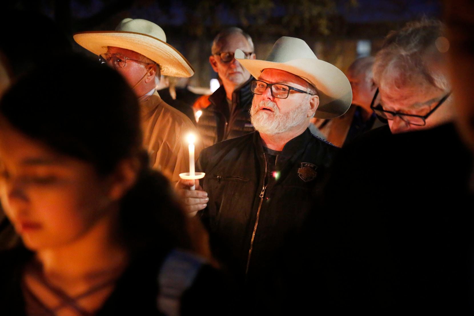 Stephen Willeford, the man who confronted and exchanged gunfire with the Sutherland Springs church shooter in 2017 (center) joined church and community members gathered outside the West Freeway Church of Christ in Fort Worth for a candlelight vigil Monday evening.