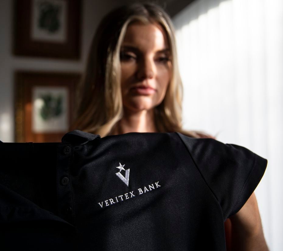 Jamie Nickerson holds a shirt she wore as a teller at Veritex Community Bank on Merrick Street on Nov. 25, 2019 in Fort Worth home. A July 2018 botched robbery at the bank left her and two other employees injured. Nickerson said she will never be a teller again. (Juan Figueroa/ The Dallas Morning News)