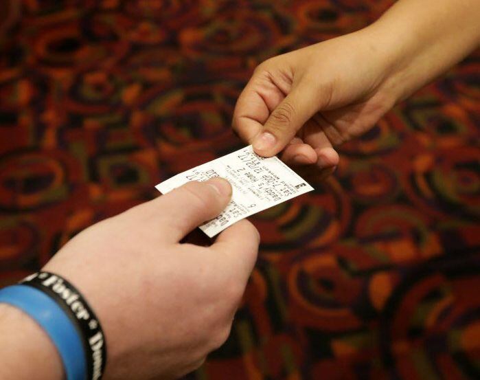 Movie ticket exchanges hands.