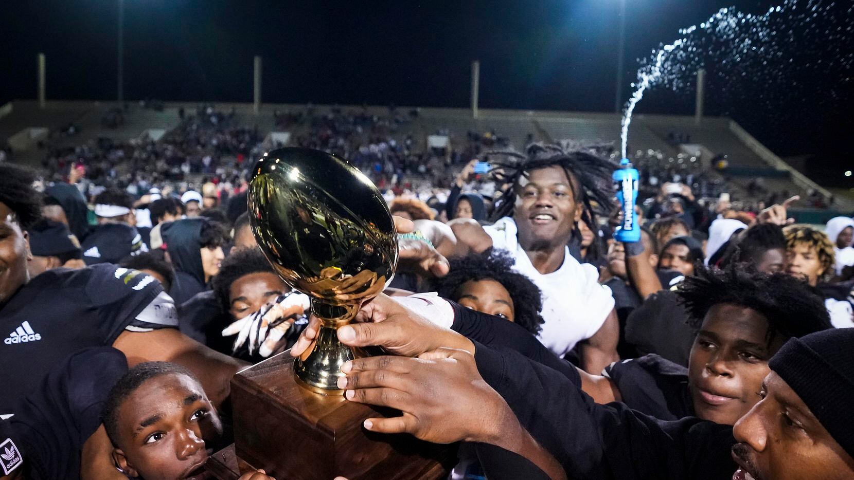 South Oak Cliff celebrates with the game trophy after a victory over Lubbock Cooper in a Class 5A Division II state semifinal at Shotwell Stadium on Friday, Dec. 10, 2021, in Abilene, Texas.