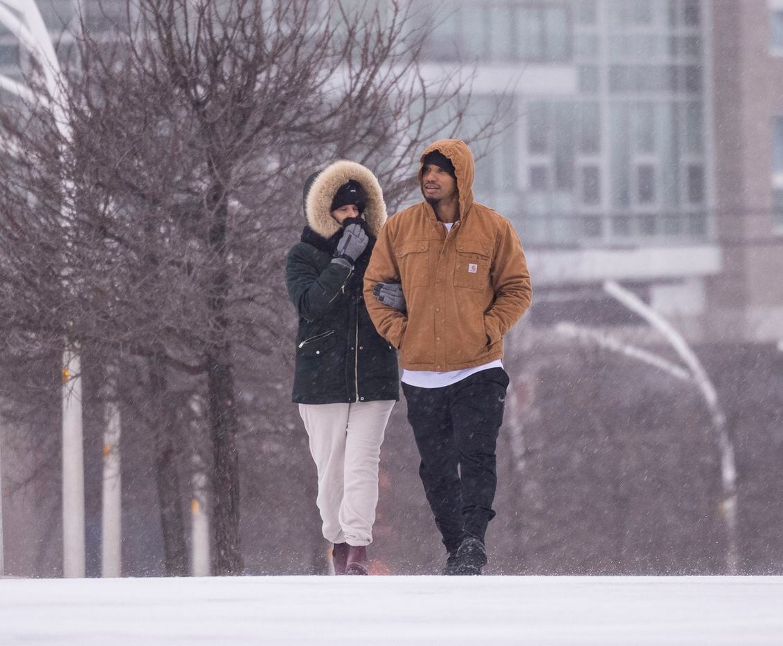 Gabriel Flores (left) and Yadi Ramos walk as sleet falls close to the Margaret Hunt Hill...