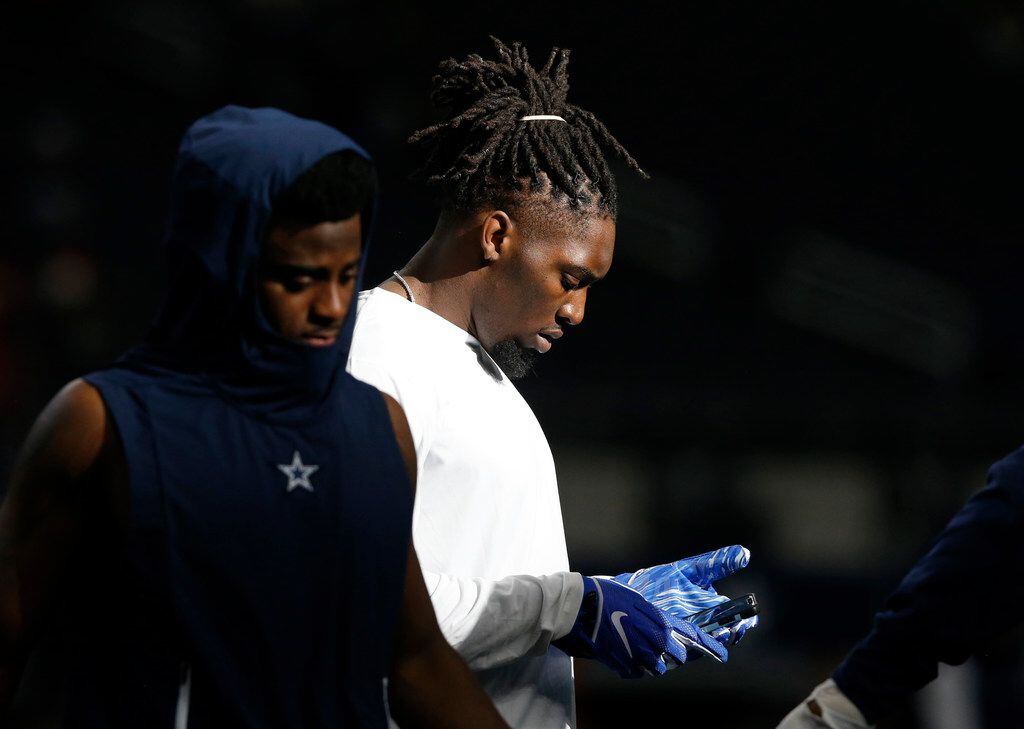 FILE - Dallas Cowboys defensive end Demarcus Lawrence (90) uses his phone before a game...