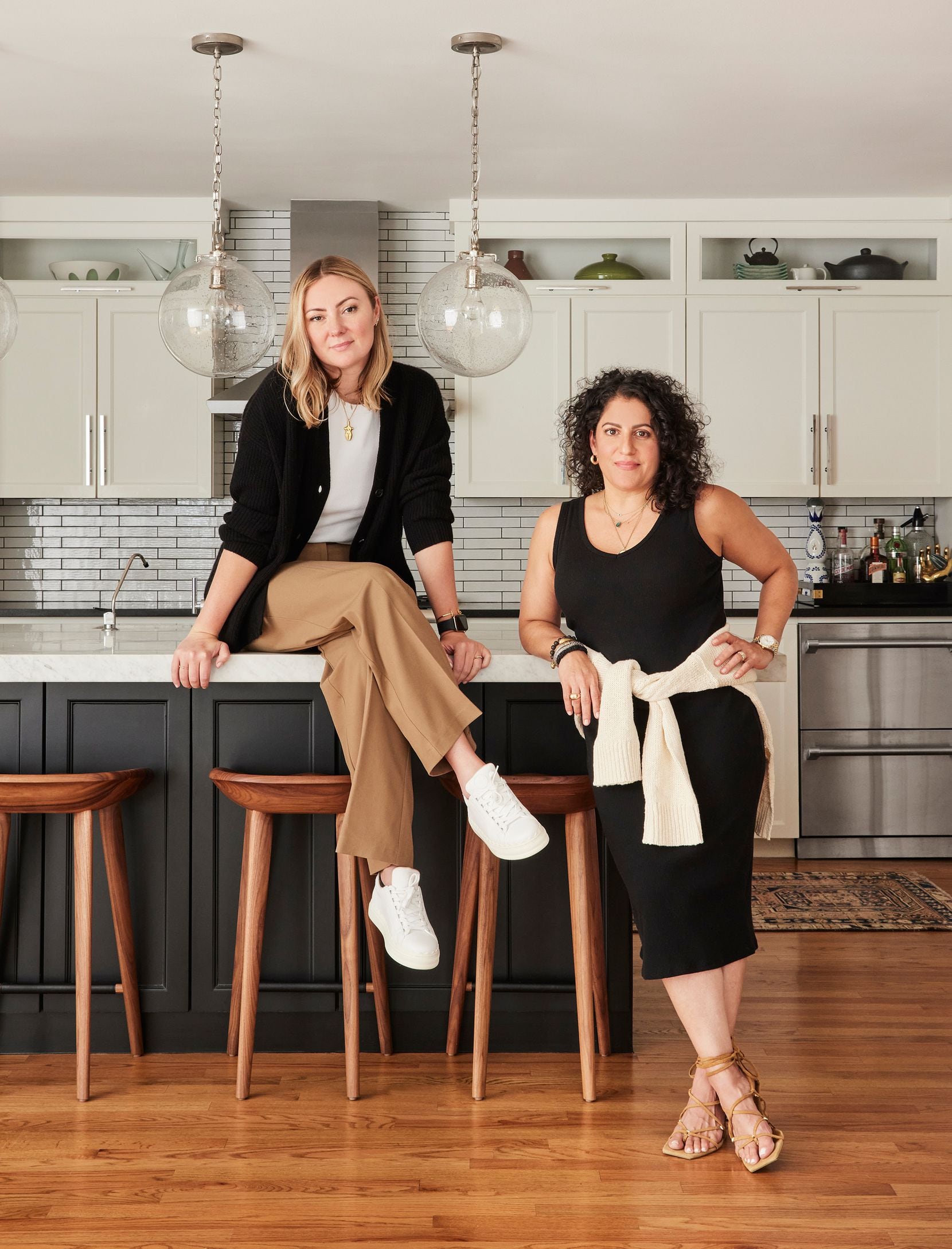 The designers pose in a kitchen.