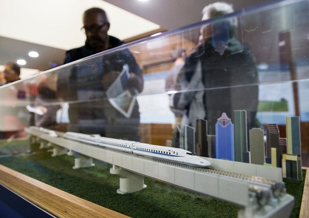 People walk past a model of a $15 billion Dallas to Houston high-speed rail line during an...