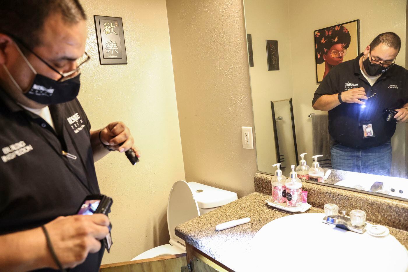 City of Mesquite Building Inspector Joe Martinez looks at the mold growing under the sink at...