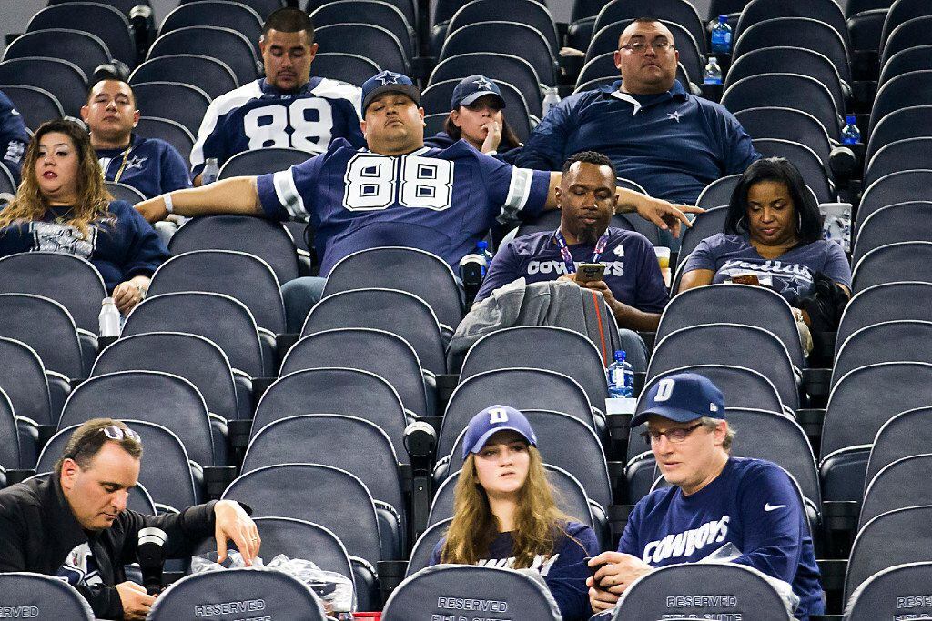 Dallas Cowboys fans sit in the stands after a loss to the Green Bay Packers in an NFC...