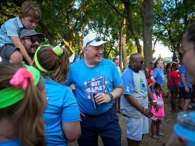 Hill & Wilkinson CEO Paul Driscoll (center) laughs with employees at opening ceremonies for...