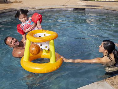 Tony Banda (à gauche) tient sa nièce Giselle Mendoza, 2 ans, alors que sa mère Imelda Mendoza regarde dans une piscine qu'ils ont louée à l'aide de l'application Swimply le 26 juillet 2020 à Waxahachie. Leur sœur Adriana Banda a déclaré qu'elle avait réservé la piscine car sa famille ne pouvait pas s'amuser l'été pendant la quarantaine.