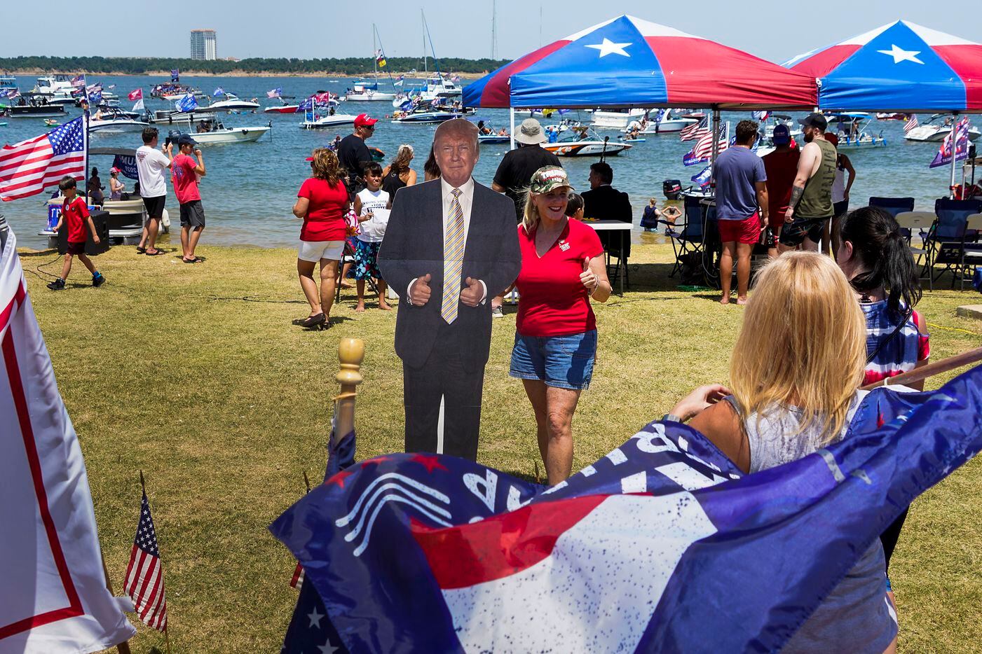 Supporters of President Donald Trump pose for photos with a cutout during a campaign rally and boat parade at Oak Grove Park on Grapevine Lake on Saturday, Aug. 15, 2020.
