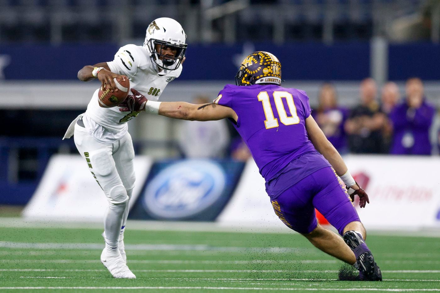South Oak Cliff quarterback Kevin Henry-Jennings (8) jumps around Liberty Hill linebacker Andon Thomas (10) during the first quarter of their Class 5A Division II state championship game at AT&T Stadium in Arlington, Saturday, Dec. 18, 2021. (Elias Valverde II/The Dallas Morning News)