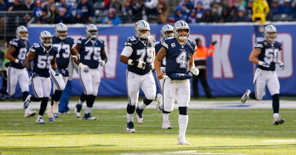 Dallas Cowboys quarterback Dak Prescott (4) leads his teammates onto the field before facing...