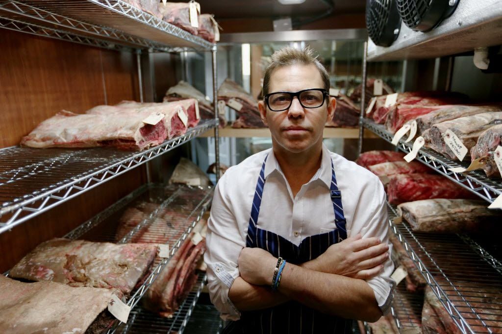 Chef John Tesar stands near dry-aged prime cuts in the meat locker at the Knife restaurant...