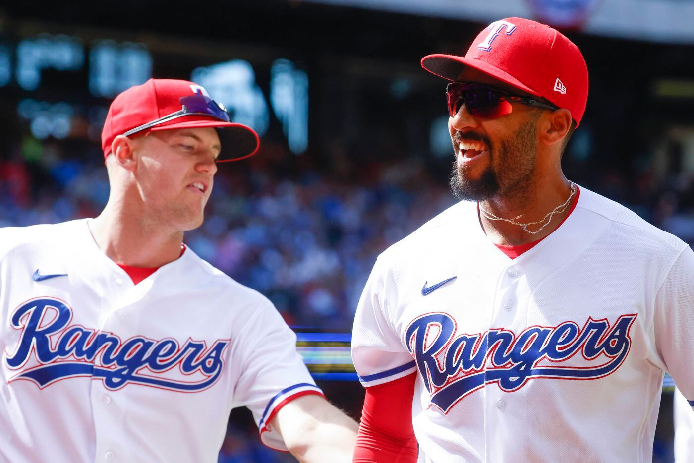 Texas Rangers second baseman Marcus Semien reacts as he returns to the dugout after tagging...