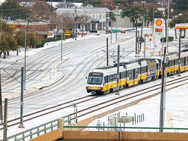A Dallas Area Rapid Transit train crosses over Northwest Highway toward the Park Lane...