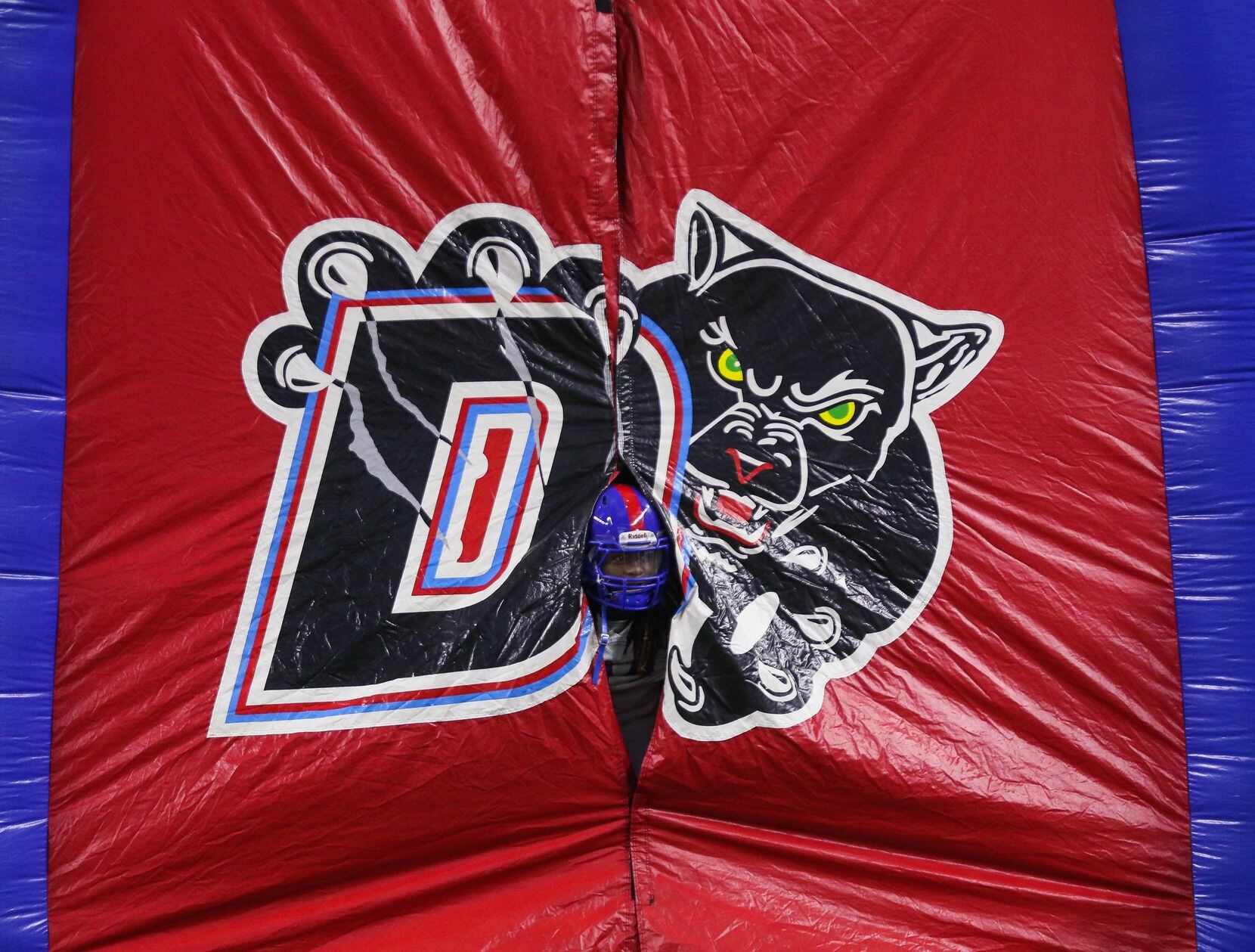 A Duncanville player peeks out of the team's inflatable sports tunnel before a Class 6A...