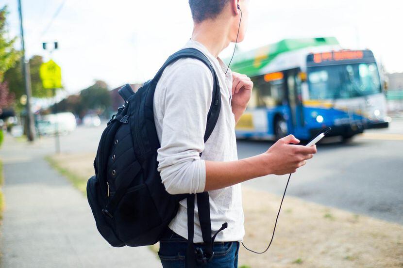 Un jovencito espera la llegada de un camión de transporte colectivo para ir a su...