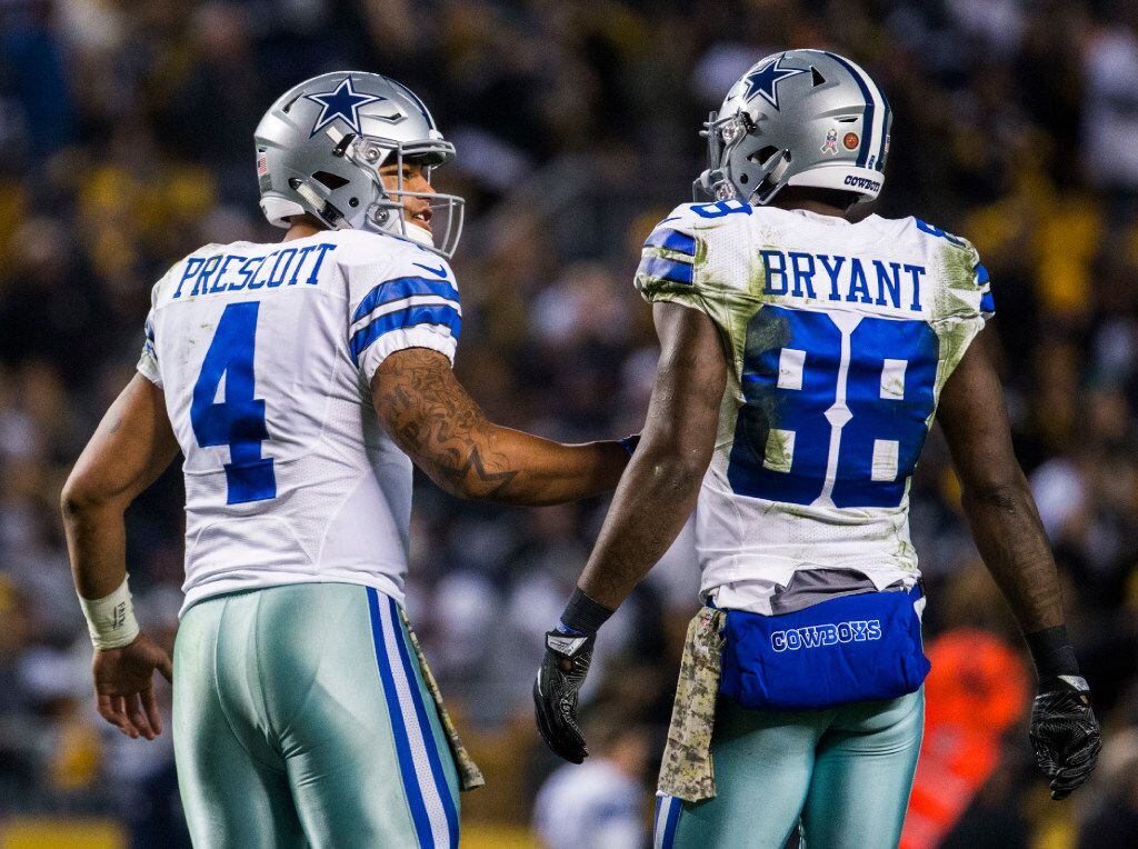 Dallas Cowboys quarterback Dak Prescott (4) talks to wide receiver Dez Bryant (88) after a...