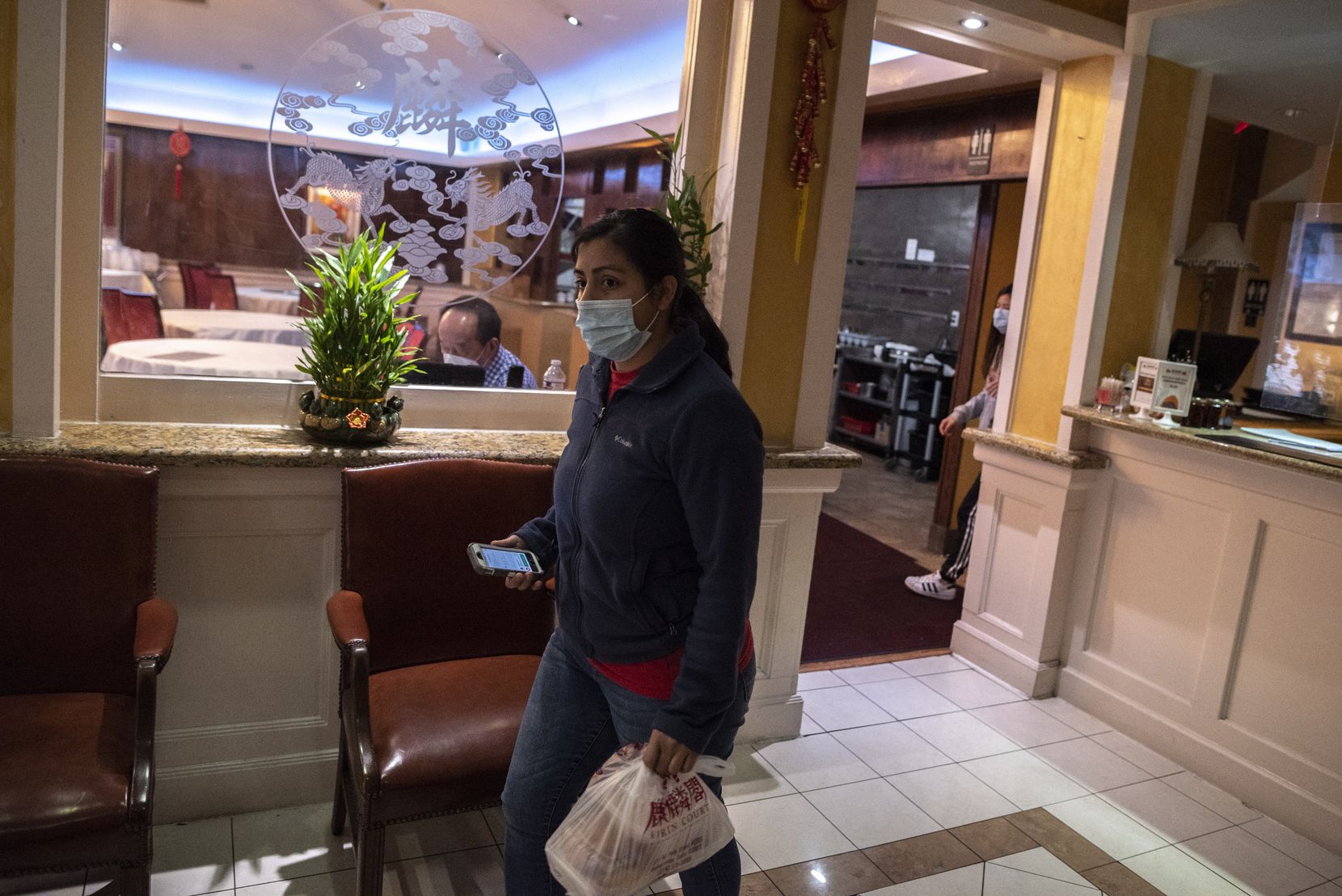 An Uber Eats driver picks-up a to-go order from Kirin Court restaurant in Richardson, on Thursday, Jan. 28, 2021. Kirin Court uses various takeout services to keep the restaurant afloat during the COVID-19 pandemic. 