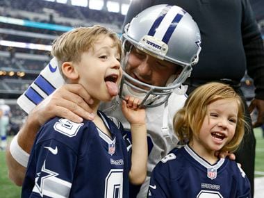 Hawkins Romo makes a face as he takes a photo with Dallas Cowboys quarterback Tony Romo as Rivers Romo looks on before a game between the Dallas Cowboys and Baltimore Ravens at AT&T Stadium in Arlington on Sunday, November 20, 2016. (Vernon Bryant/The Dallas Morning News)