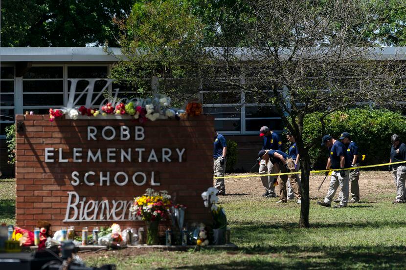 FILE - Investigators search for evidence outside Robb Elementary School in Uvalde, Texas,...