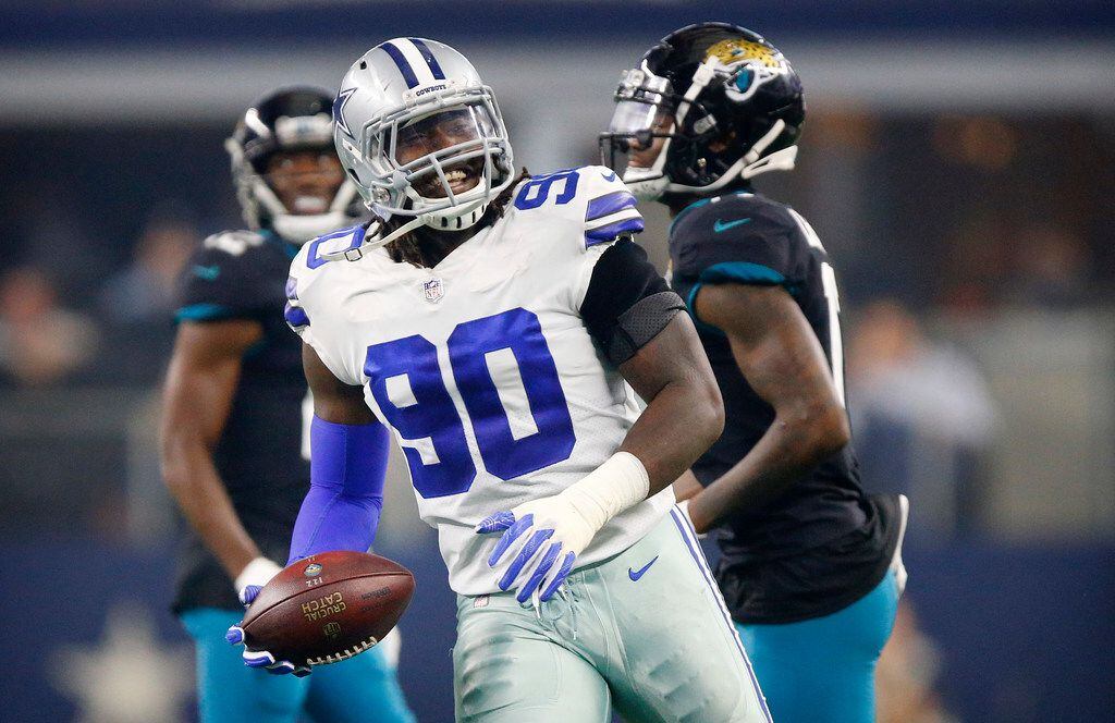 FILE - Cowboys defensive end DeMarcus Lawrence (90) flashes a smile after he helped break up...