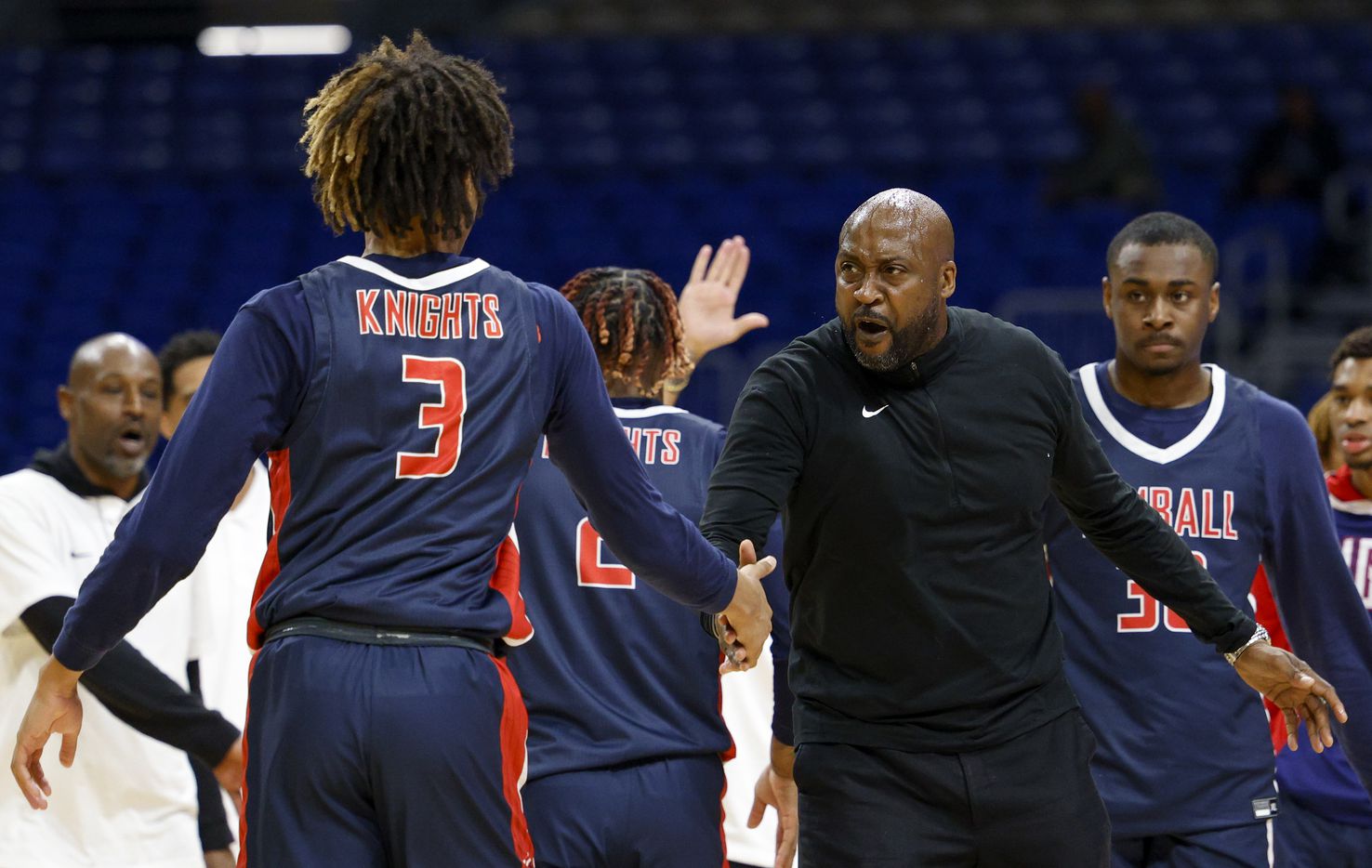 Kimball head coach Nicke Smith high-fives Kimball guard Chauncey Gibson (3) during the first...