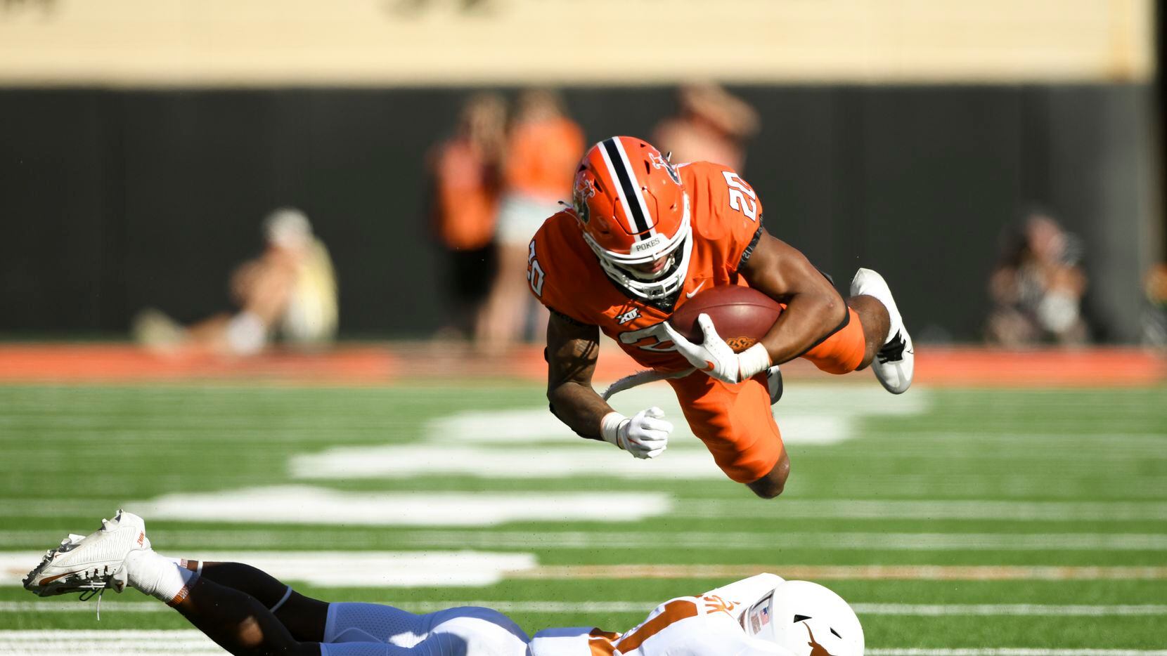 Oklahoma State running back Dominic Richardson (20) launches himself over Texas defensive...