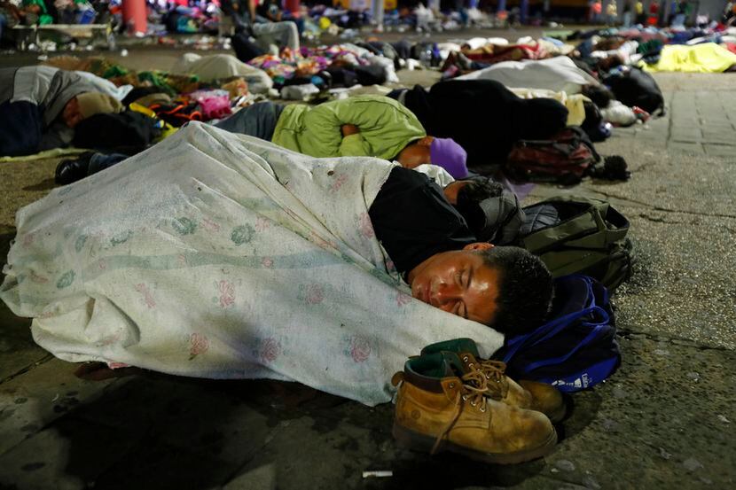 Migrantes hondureños que esperan llegar a Estados Unidos duermen en una plaza pública en la...