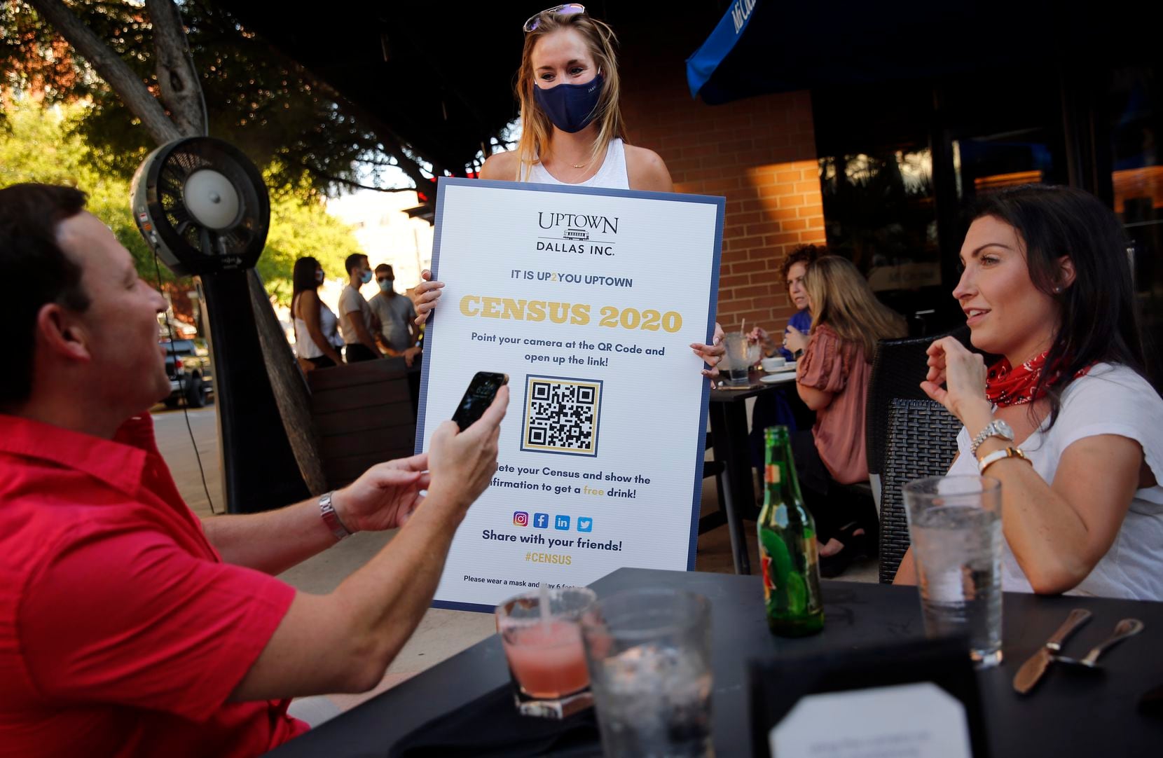 Uptown Dallas volunteer Christie Myers (center) encourages Darren Houck (left) and his friend Michelle Sloan (right) to register with Census 2020 outside Mi Cocina at West Village shopping center in Dallas, Thursday, August 20, 2020. Those who registered received free drinks onsite from Bubble Bus Co. (Tom Fox/The Dallas Morning News)