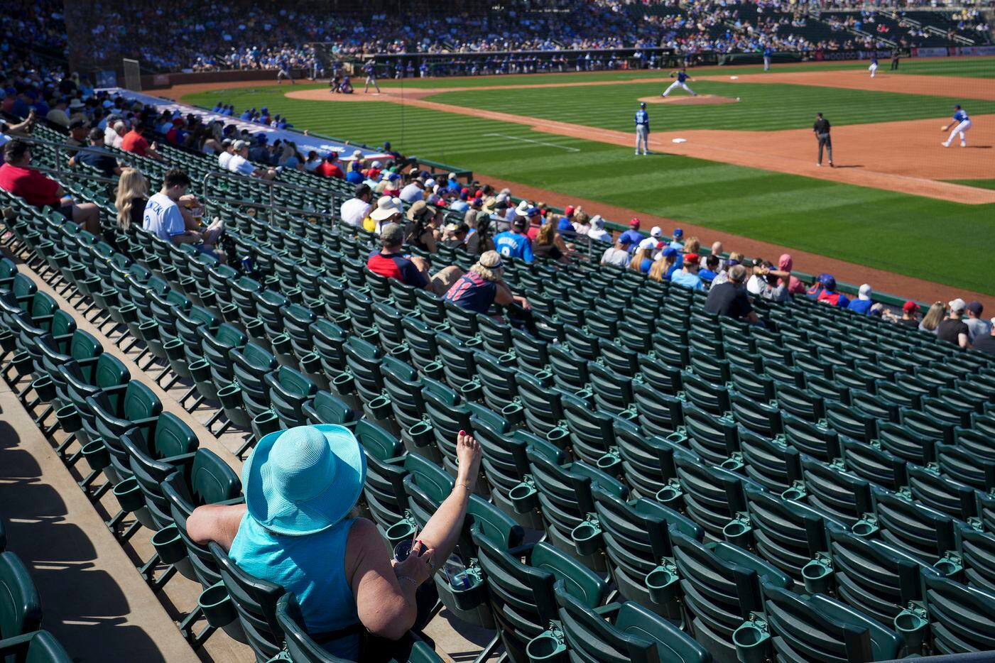 Fans relax in the sunshine during the fourth inning of a spring training game between the...