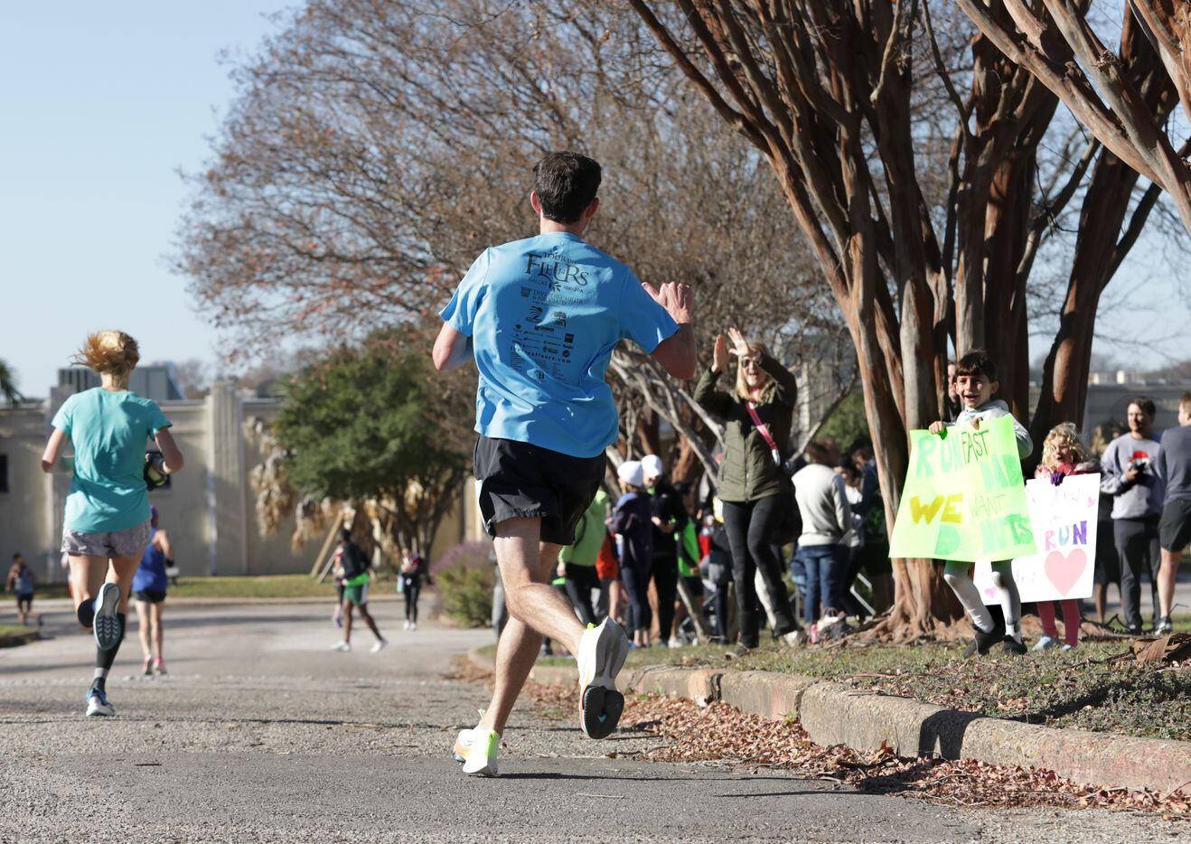 Fans cheer as runners approach the 16 mile marker during the BMW Dallas Marathon at White...