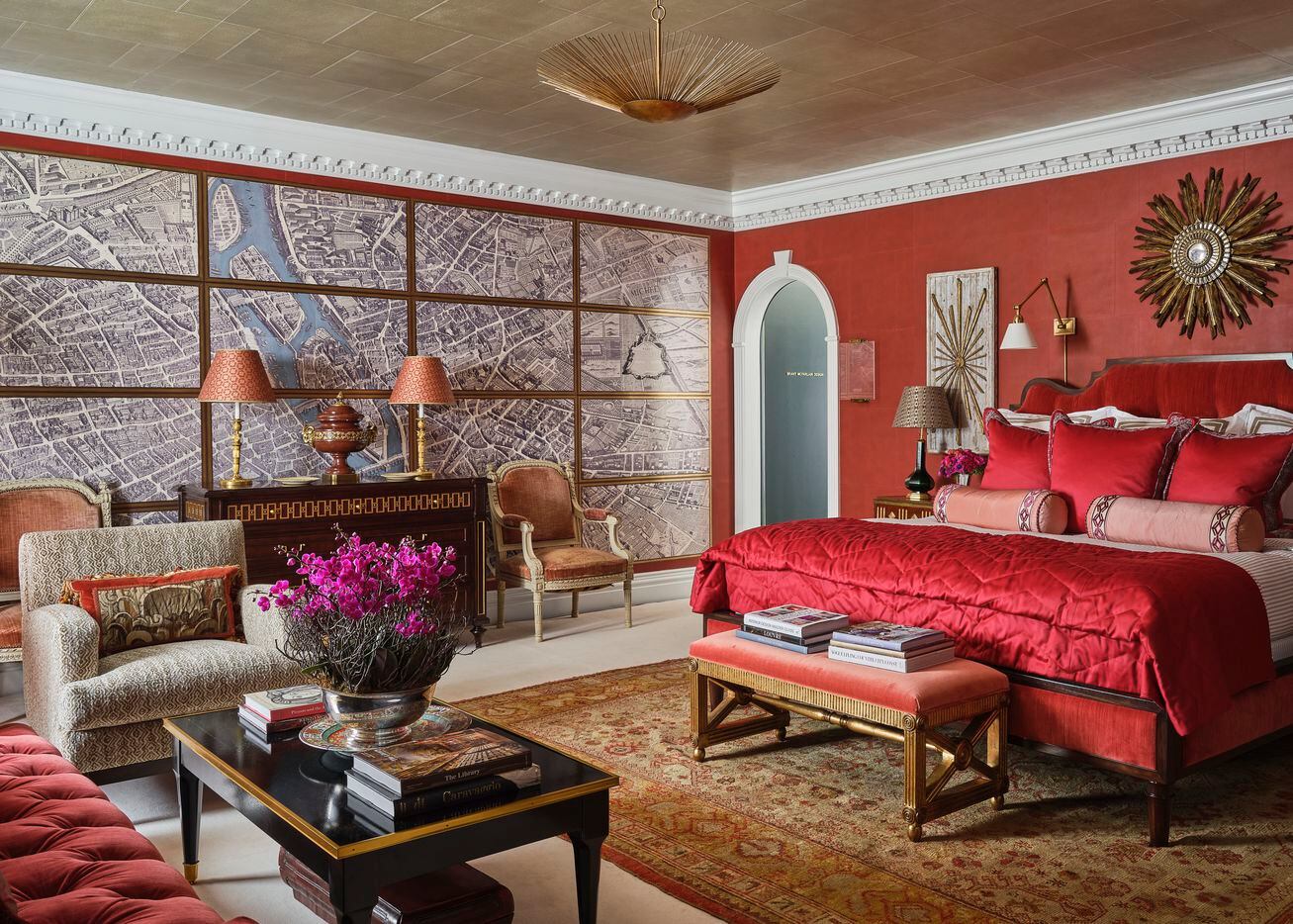 Alexa Hampton for Mark Hampton LLC designed the upstairs primary bedroom at the 2021 Kips Bay Decorator Show House Dallas. The room is full of bright, powerful red tones and artful details like built-in bookcases and plaster moldings.