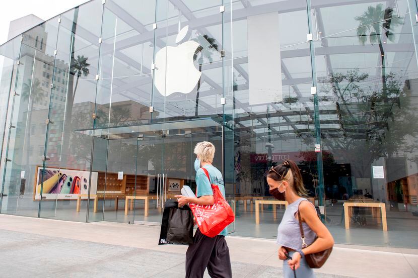 Personas con mascarillas caminan frente a una Apple Store en Santa Mónica, California.