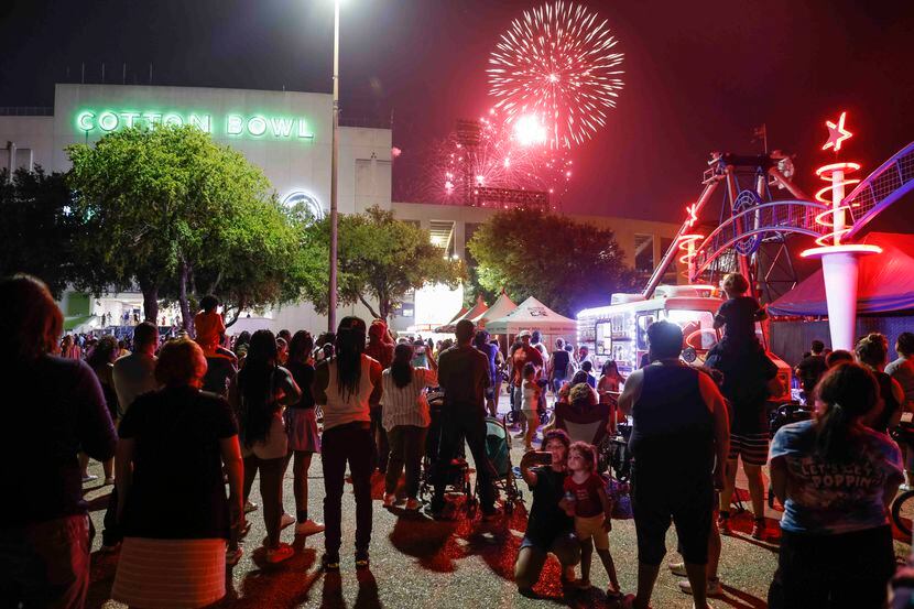 People watch as the fireworks explode during an Independence Day celebration at Fair Park’s...