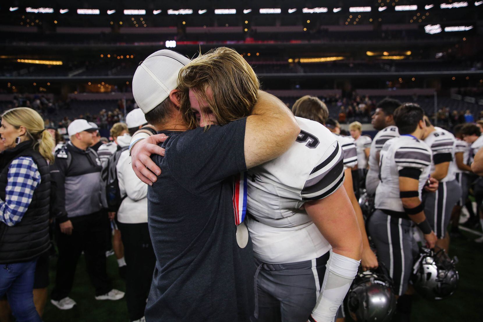 Denton Guyer's Connor Briggs (9) receives a hug after losing a Class 6A Division II state...