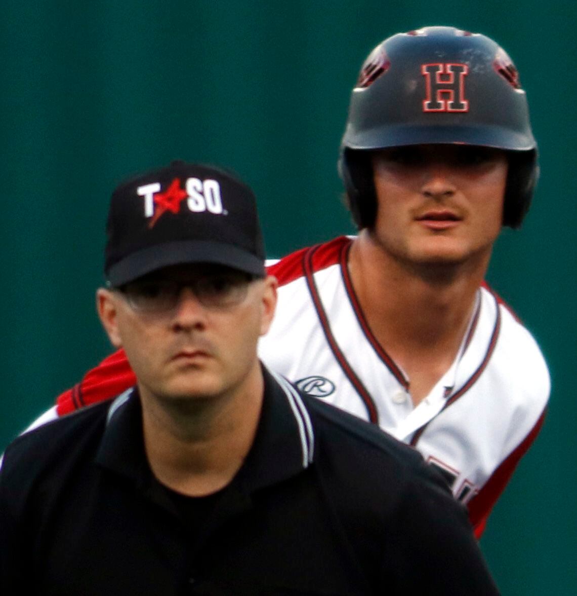 Rockwall Heath baserunner Casey Curtin (1) peers over the shoulder of the base umpire as he...