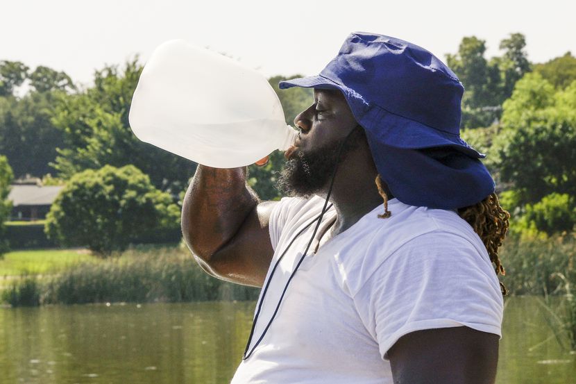 Alexander Nixon, of Dallas, drinks water while working out at White Rock Lake, Monday, July...