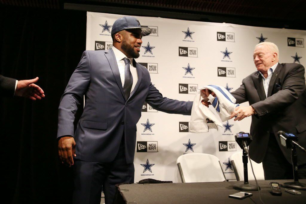 Running back Ezekiel Elliott, who played for Ohio State, reaches for his jersey from Dallas...