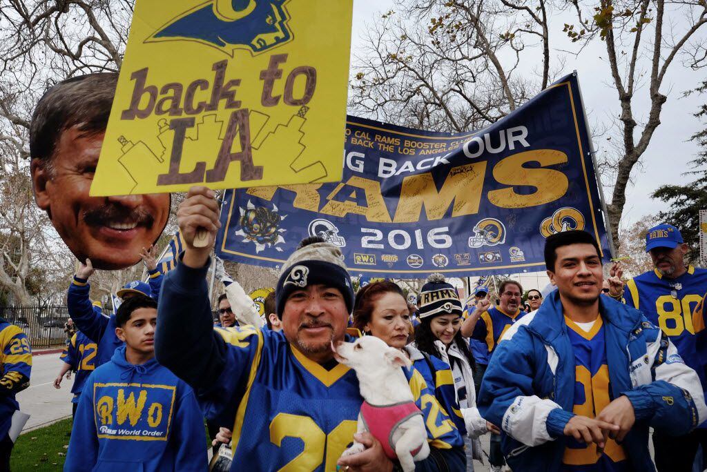 In this Saturday, Jan. 9, 2016 photo Felix Gonzalez, center, and his dog Milo join Rams fans...