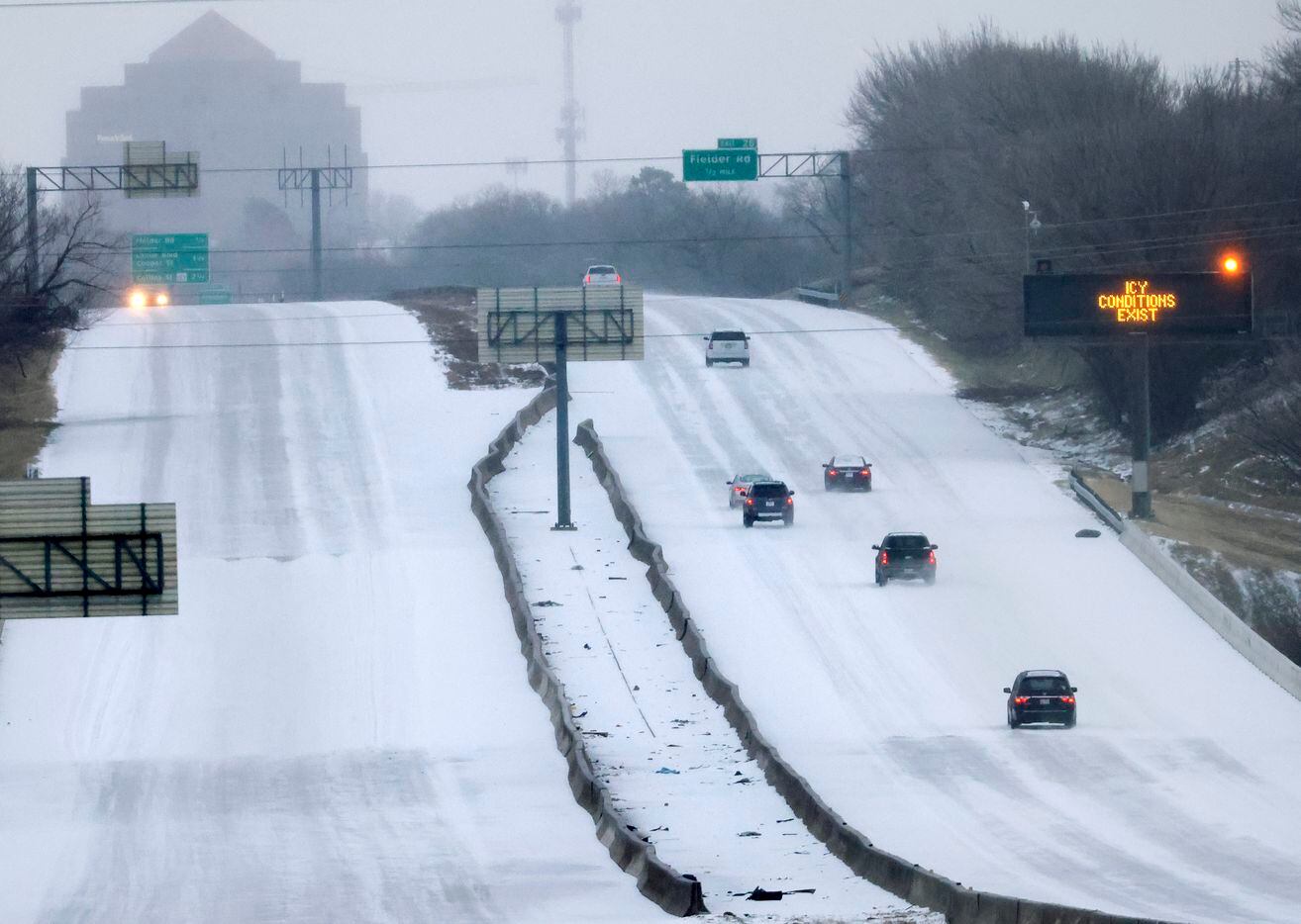 Drivers navigate sleet-covered Interstate 30 as they enter into Arlington, Texas, February...