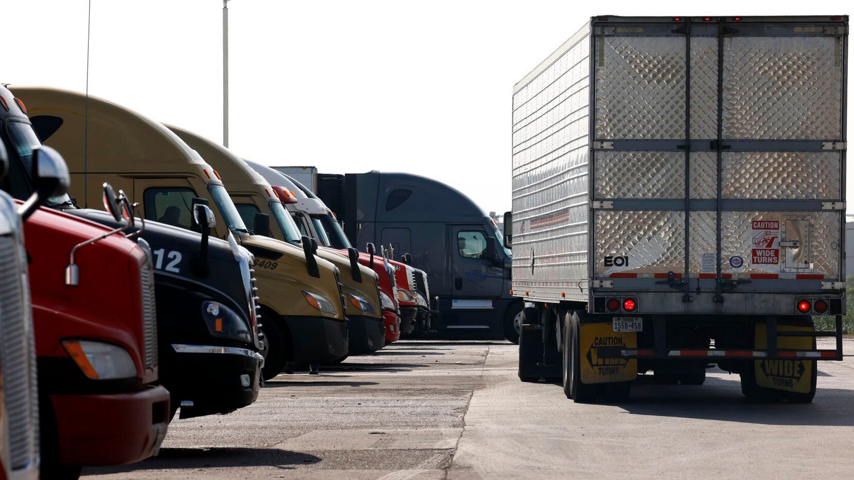Varios camiones de carga se estacionan en espera de ser inspeccionados por autoridades de...