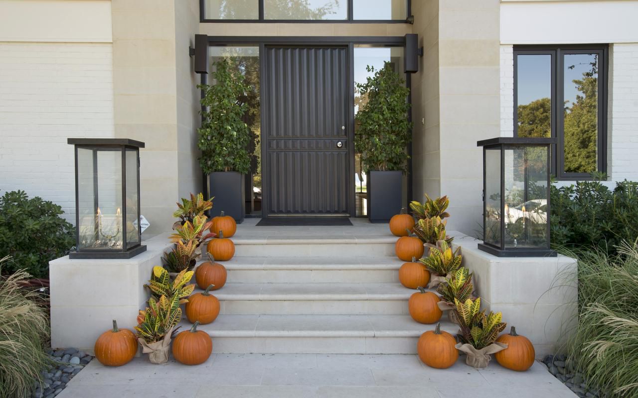 
Placing colorful crotons alongside a row of orange pumpkins (above) is a simple, modern way...