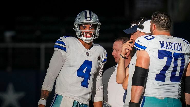 Dallas Cowboys quarterback Dak Prescott (4) smiles as he talks with offensive coordinator...