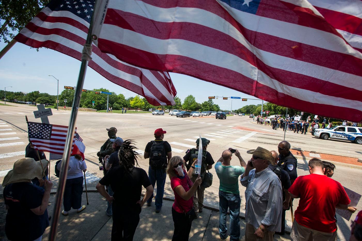 Anti-Shariah protesters stand at the intersection of Abrams Road and Centennial Boulevard...