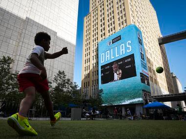 Younsters play soccer on the lawn after Dallas was announced as a host city for the 2026...