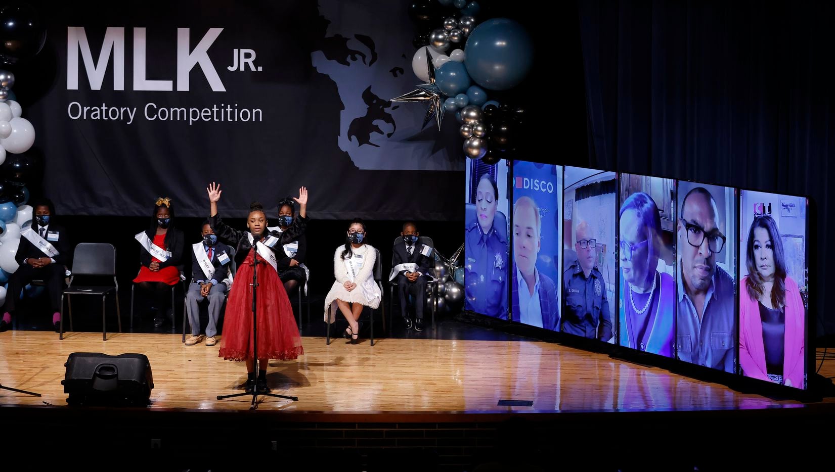 Fifth grader Jaliaha Rodgers of JP Sparks Math, Science and Technology Vanguard delivers her speech before virtual judges (right) during the 30th Annual Foley & Lardner MLK Jr. Oratory Competition at W.H. Adamson High School in Dallas, January 14, 2022. She was runner-up in the competition.