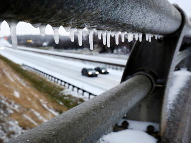 Freezing rain from overnight created icicles on a bridge crossing Interstate 30 in East Fort Worth, February 3, 2022. Drivers navigated sleet-covered roads Thursday morning. 