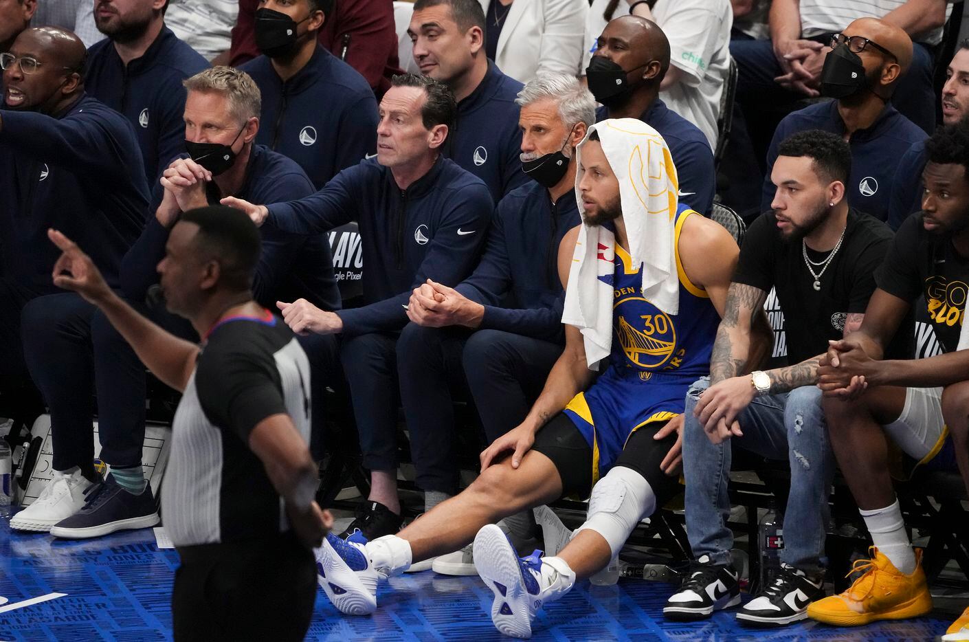 Golden State Warriors guard Stephen Curry (with towel on head) watches from the bench during...