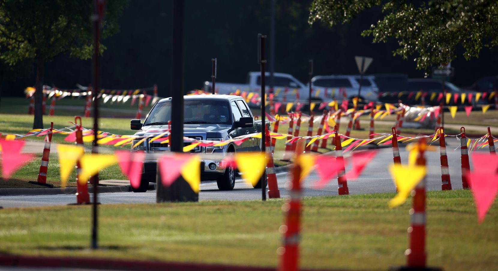 A vehicle makes it way through a maze of traffic cones and flags prior to the start of the...